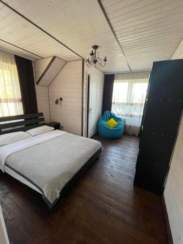 a bedroom with a large bed and a blue ottoman at Котедж VIKTORIA in Migovo