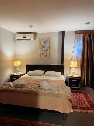 a bedroom with a large bed and two lamps on tables at Boutique Hotel Gold Tbilisi in Tbilisi City