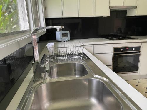 a kitchen with a sink and a dish drying rack at Coral House in Sydney