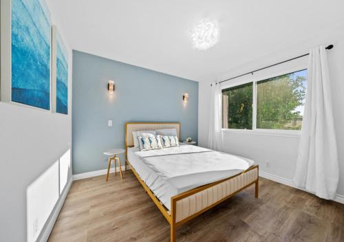 una camera da letto con un letto e una grande finestra di #Marbella Lane - Modern Home with Private Backyard a Fullerton
