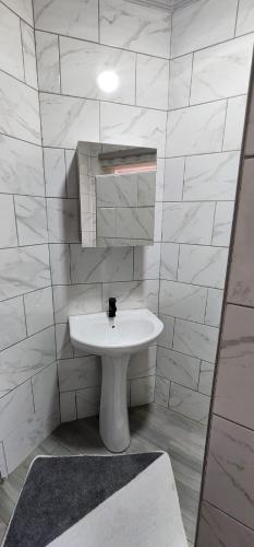 a white bathroom with a sink and a mirror at Strictly Halaal Brand New Self Catering Apartment in Lenasia
