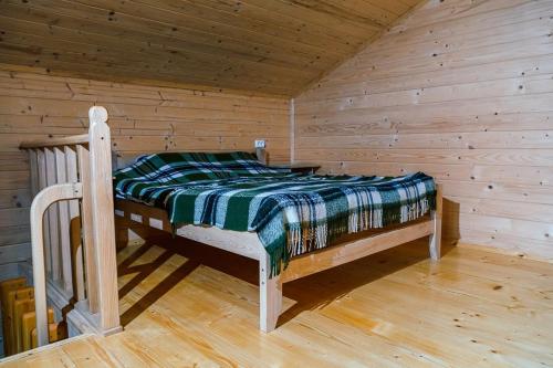a bed in a wooden cabin with a wooden floor at Котедж Ксенія in Dzembronia