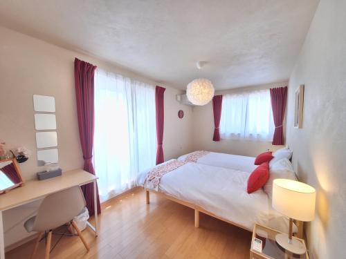 a small bedroom with a bed with red pillows at Peaceful Garden Home in Ota, Entire 3BR Parking in Ota