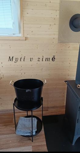 a black laundry basket sitting in a room with a wall at Maringotka U Skalek in Hlavňovice