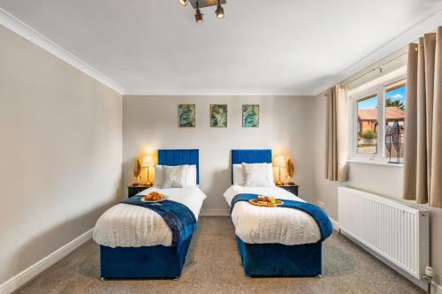 two beds in a room with blue and white at Large House New Haven - East Sussex - Sleeps 10 People - Contractors - Families - Discounts for Long Term Bookings! in Newhaven