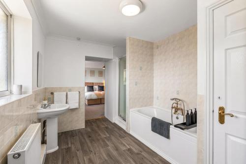 a bathroom with a white tub and a sink and a bath tub at Large House New Haven - East Sussex - Sleeps 10 People - Contractors - Families - Discounts for Long Term Bookings! in Newhaven