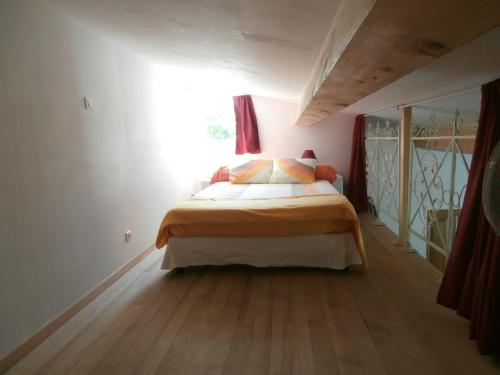 1 dormitorio con 1 cama con sábanas de color naranja y blanco en La Mouchelière, en La Garde-Freinet