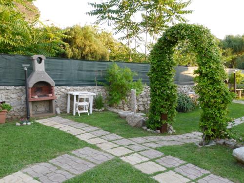 a garden with an arch and an outdoor oven at Le Casette Sul Mare in Capo Vaticano