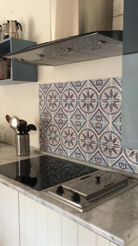 una cucina con fornello e paraschizzi in piastrelle di Villa Meigama - Porto Giunco a Notteri