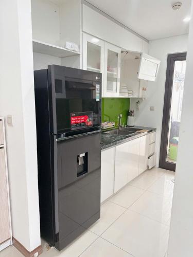 a kitchen with a black refrigerator with a microwave at Rio House district 10 Saigon Centrosa in Ho Chi Minh City