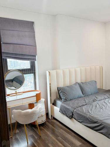 a bedroom with a bed and a mirror and a chair at Rio House district 10 Saigon Centrosa in Ho Chi Minh City