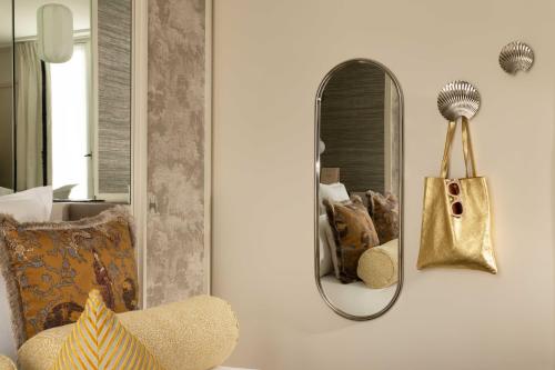 a mirror on a wall with a chair and a purse at Hôtel l'Inattendu in Paris