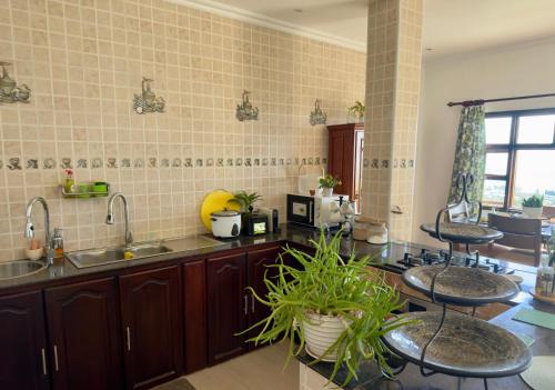 a kitchen with two bar stools and a sink at 180 Degrees Self-Catering in Victoria