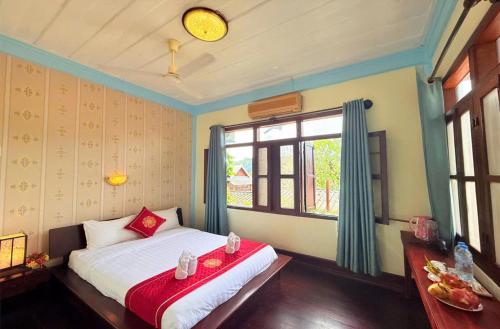 a bedroom with a bed and a window at Luang Prabang Manichan Villa in Luang Prabang