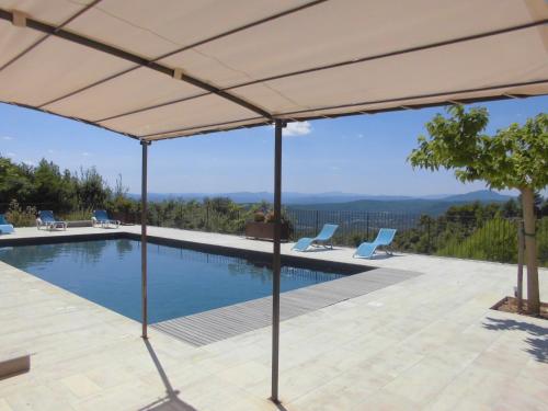- une piscine avec un grand parasol sur la terrasse dans l'établissement Résidences Les Bernardins, à Tourtour
