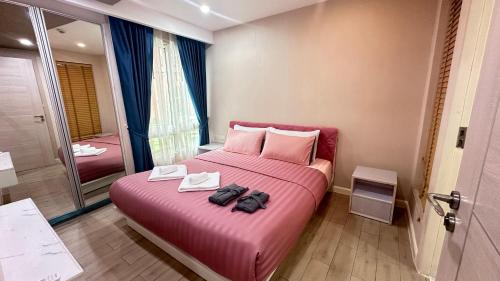 sypialnia z różowym łóżkiem z 2 torbami w obiekcie Sevenseas คอนโดสวนน้ำจอมเทียน พัทยา byส้ม w mieście Jomtien Beach