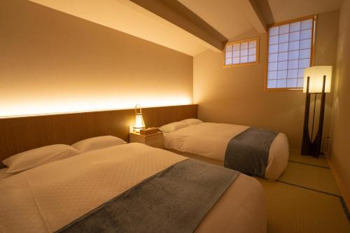 a bedroom with two beds and a window at KONJAKUSO OSAKA TSUTENKAKU MUSHIBUROYA Sauna Villa in Osaka