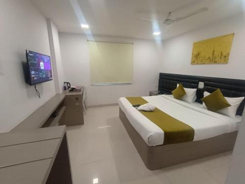 a bedroom with a bed and a tv in it at La Riviera Suites in Hyderabad
