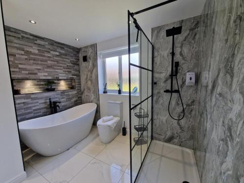 un baño con bañera y ducha en Family Retreat, 6 bedrooms, sleeps 12 Near National Park And Bike Park Wales, en Pontsarn Station