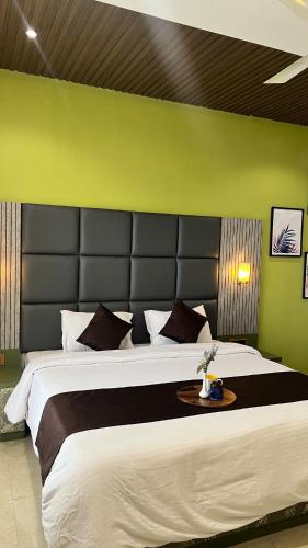 a bedroom with a large bed with a green wall at 4BHK Cozy Villa with Pvt Pool in Panchgani