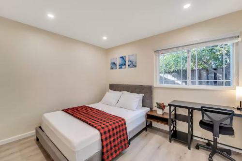 ein Schlafzimmer mit einem Bett, einem Schreibtisch und einem Fenster in der Unterkunft Remodel 3 bedrooms 2 full bath home free laundry,Wi-Fi, Parking in San Jose