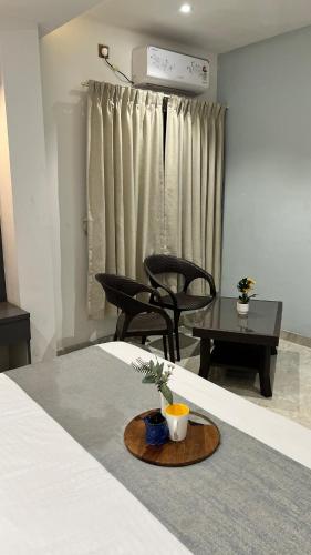 a room with a bed with a table and chairs at 4BHK Cozy Villa with Pvt Pool in Panchgani