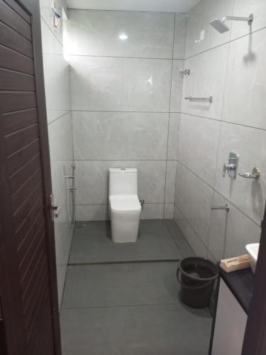 a white bathroom with a toilet and a shower at The Fortunara Crown Munnar in Munnar