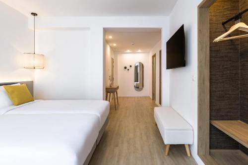 a bedroom with a white bed and a tv at Hotel Adonis Pelinor in Santa Cruz de Tenerife