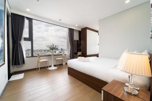 a hotel room with a bed and a desk with a table at The Silver Vinh Hoi Apartment in Ho Chi Minh City
