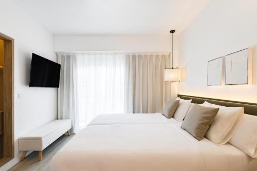 a hotel room with a large white bed and a window at Hotel Adonis Pelinor in Santa Cruz de Tenerife