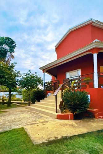 a red house with stairs in front of it at casa Luis in São Tomé