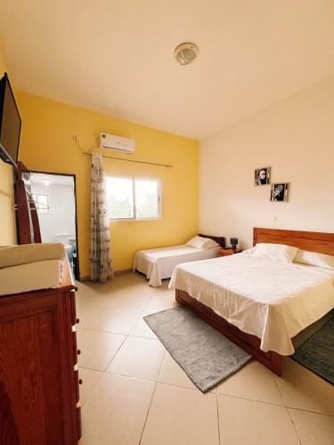 a large bedroom with two beds and a window at casa Luis in São Tomé