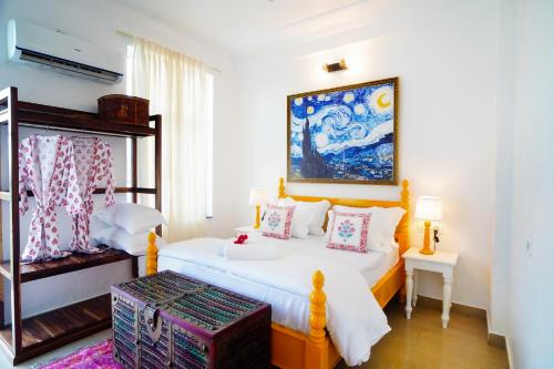 a bedroom with a bed and a painting on the wall at Met Luxe Galleria in Jaipur