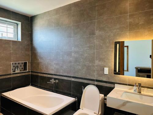 a bathroom with a tub and a toilet and a sink at Myhoa Lagoon - Kiting Town in Phan Rang