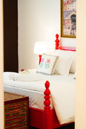 two beds with red posts in a bedroom at Met Luxe Galleria in Jaipur