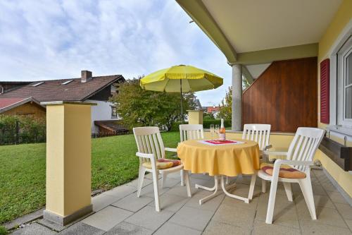 a table and chairs with an umbrella on a patio at Residenz Sonnenhang II in Füssen