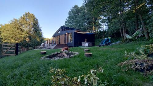 a tiny house in the middle of a yard at KOCIEWSKA DACZA - domek o podwyższonym standardzie, POMORSKIE, RZEKA, LASY, ŁĄKI in Pogódki