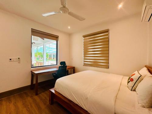 a bedroom with a bed and a desk and a window at Myhoa Lagoon - Kiting Town in Phan Rang