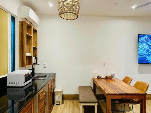 a kitchen with a wooden table and a microwave at Myhoa Lagoon - Kiting Town in Phan Rang