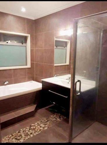 a bathroom with a tub and a sink and a shower at 10a monowai street, bayfair in Mount Maunganui