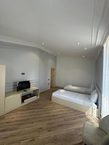 una stanza bianca con un letto e una tv di Penthouse Panorama a Baku