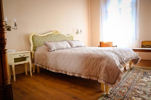 a bedroom with a bed and a table and a window at Sibla Residence, Unique Experience Heritage House in Lugoj