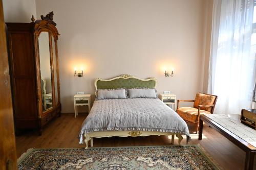 a bedroom with a bed and a mirror and a chair at Sibla Residence, Unique Experience Heritage House in Lugoj