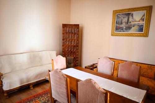 a living room with a table and chairs and a couch at Sibla Residence, Unique Experience Heritage House in Lugoj