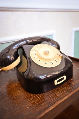 a black phone sitting on top of a table at Sibla Residence, Unique Experience Heritage House in Lugoj