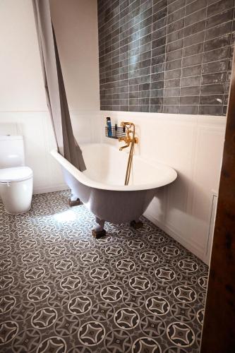 a bathroom with a tub and a toilet at Sibla Residence, Unique Experience Heritage House in Lugoj