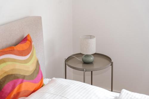 a table with a lamp on it next to a bed at Skyrise Apartments - Stilvoll wohnen, entspannt genießen in Bad Wörishofen