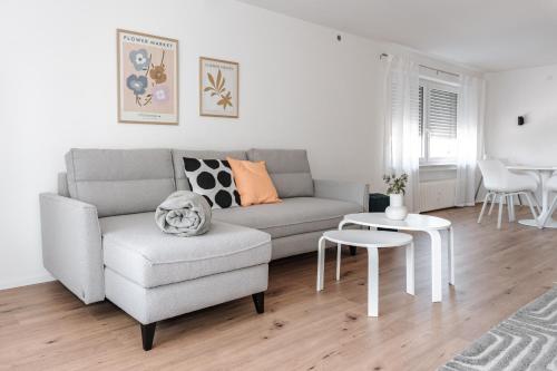 a living room with a couch and a table at Skyrise Apartments - Stilvoll wohnen, entspannt genießen in Bad Wörishofen