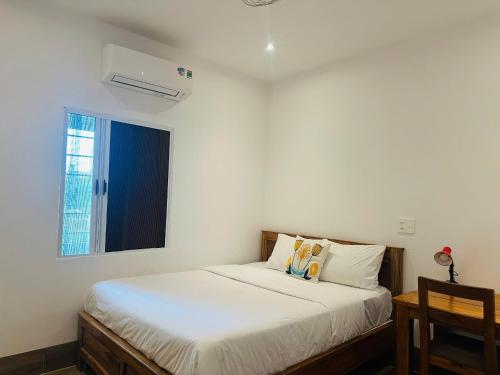a bedroom with a white bed with a window at Myhoa Lagoon - Kiting Town in Phan Rang