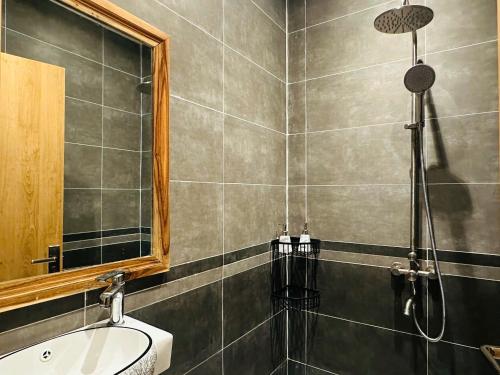 a bathroom with a shower with a sink and a mirror at Myhoa Lagoon - Kiting Town in Phan Rang